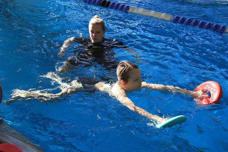 Schulkinder lernen in den Herbstferien schwimmen
